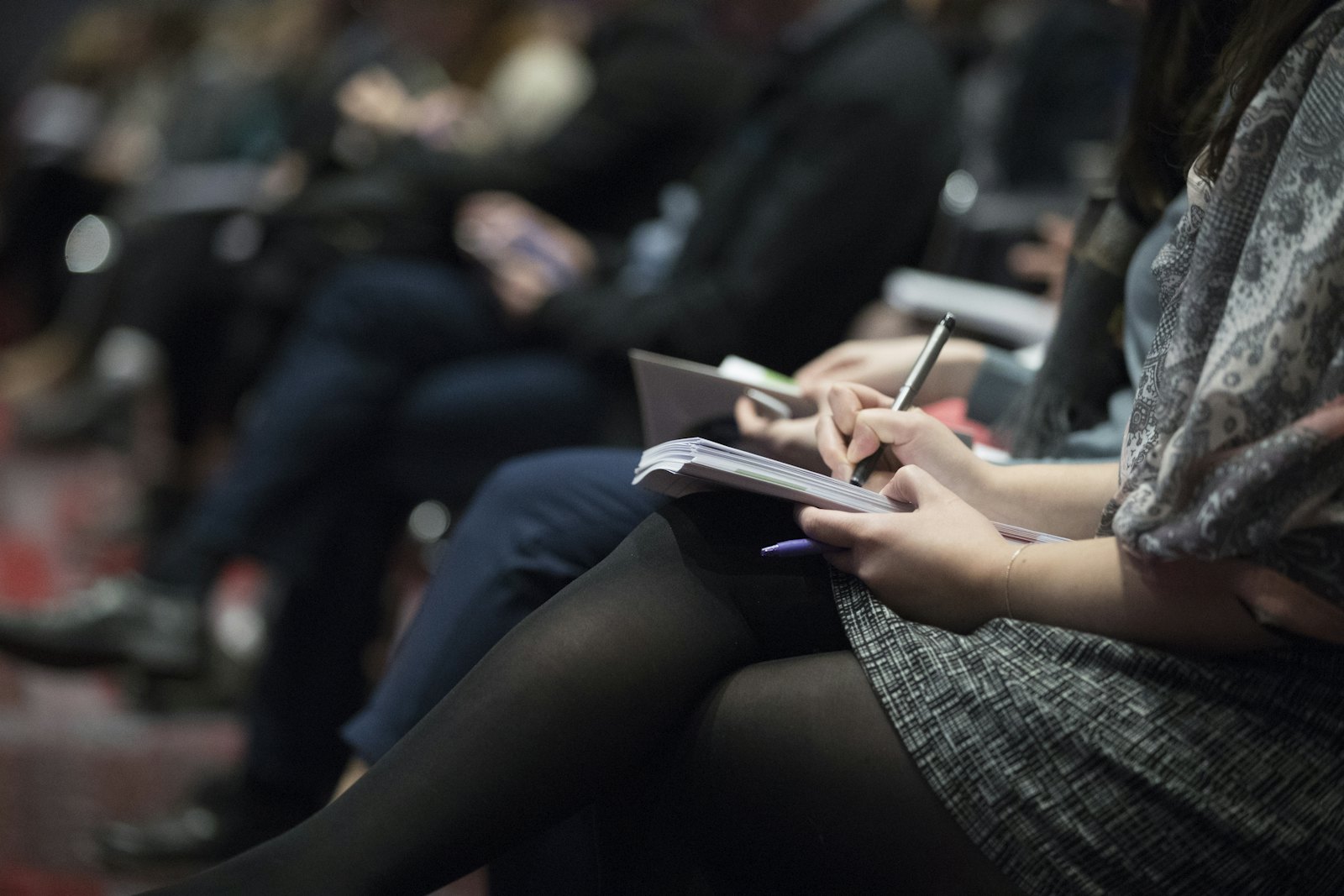 People writing in notebooks during a workshop session