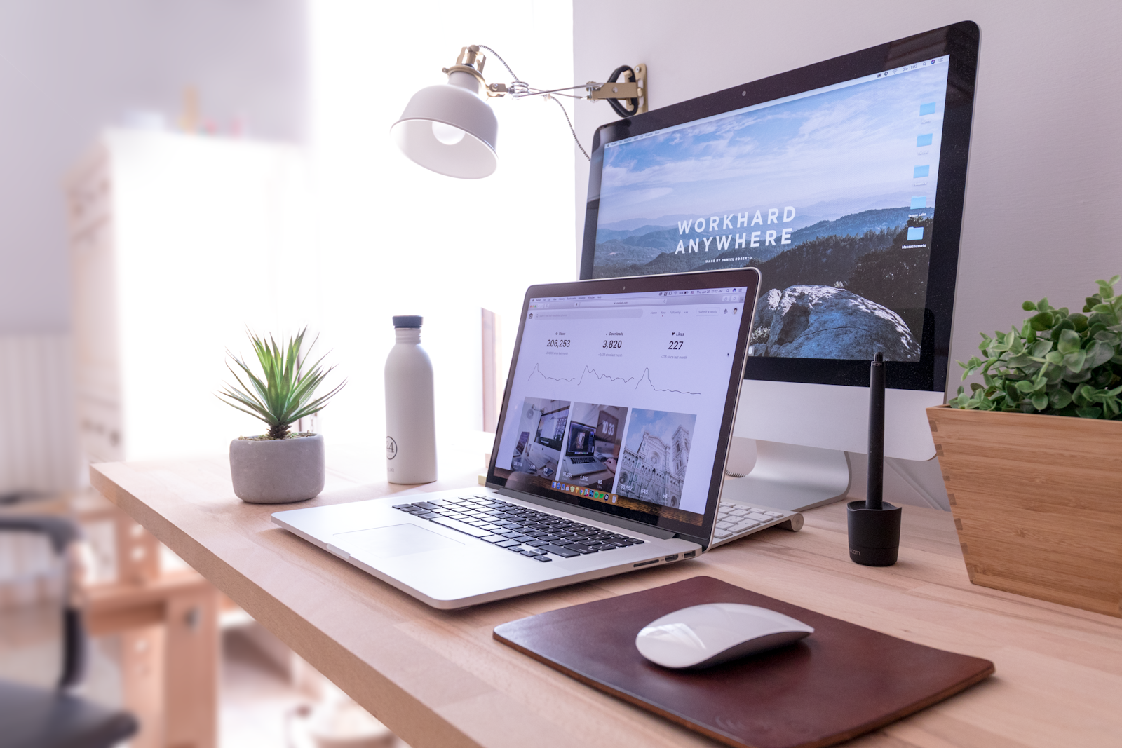 A laptop and desktop screen side by side on a desk