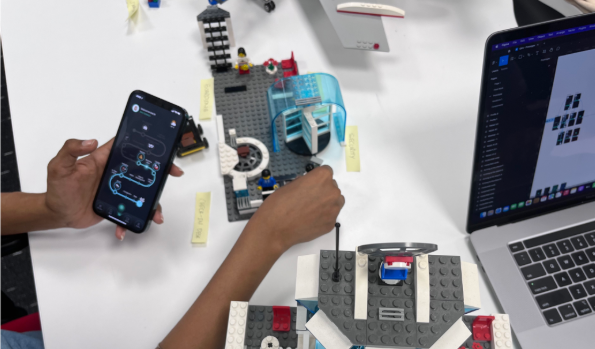 Participants navigating a LEGO® airport set with the app on a phone