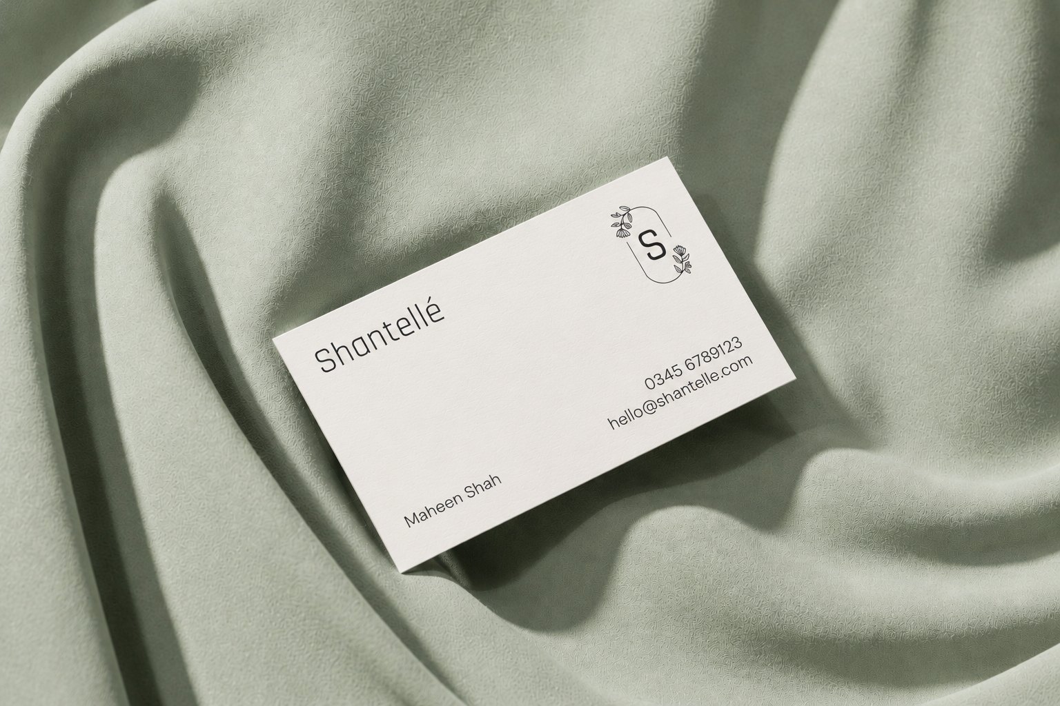 The card in charcoal on ivory, staged on sage silk