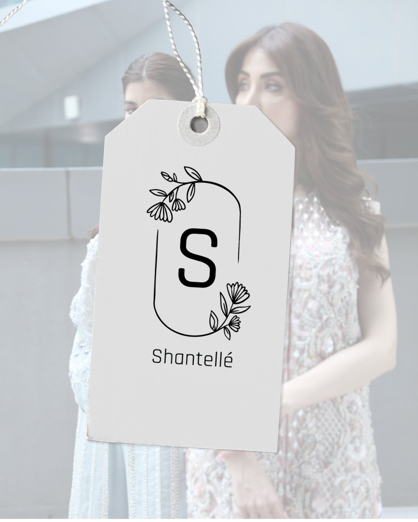 The swing tag hanging against a campaign shot, the mark at garment scale